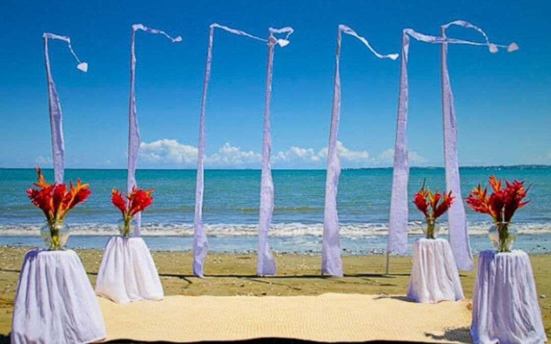 Elegant flags fluttering on a beach in Algarve, creating a stunning backdrop for a beach wedding celebration.