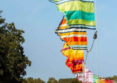 Bright and colorful festival flags in the UK, fluttering under the summer sun at an outdoor event.