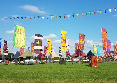 Festival flags in the UK displayed on a large banner, adding vibrant colors and energy to the outdoor event space.