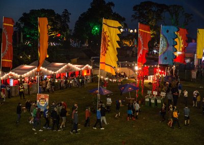 Festival flags illuminated at a night event in Europe, adding vibrant colors and energy to the evening atmosphere.