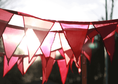 Colorful bunting flags from Festival Flag Company, available in 100 colors, enhancing the atmosphere of an outdoor event.